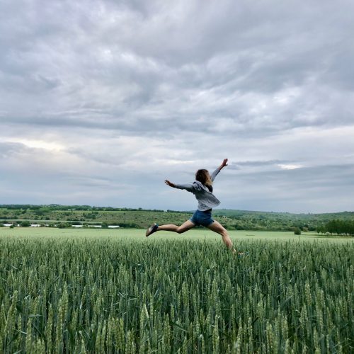 woman-running-in-a-field-of-wheat-2022-11-15-09-47-41-utc